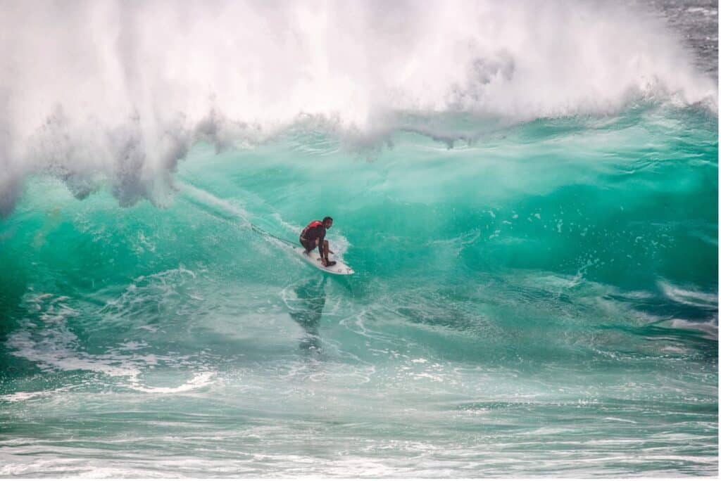 Ein Surfer reitet auf einer Welle als Symbol für resiliente Krisen-PR: Wellen reiten statt vermeiden. 