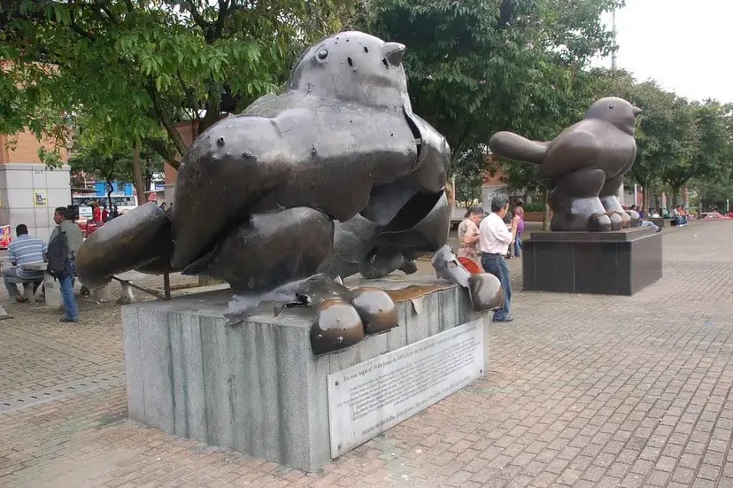 Eine kaputte Vogelstatue steht neben einer intakten Vogel-Statue