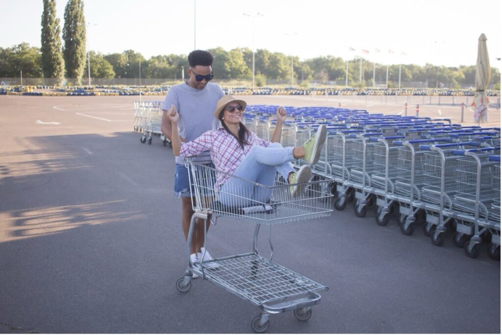 Man pushing a woman in a shopping basket