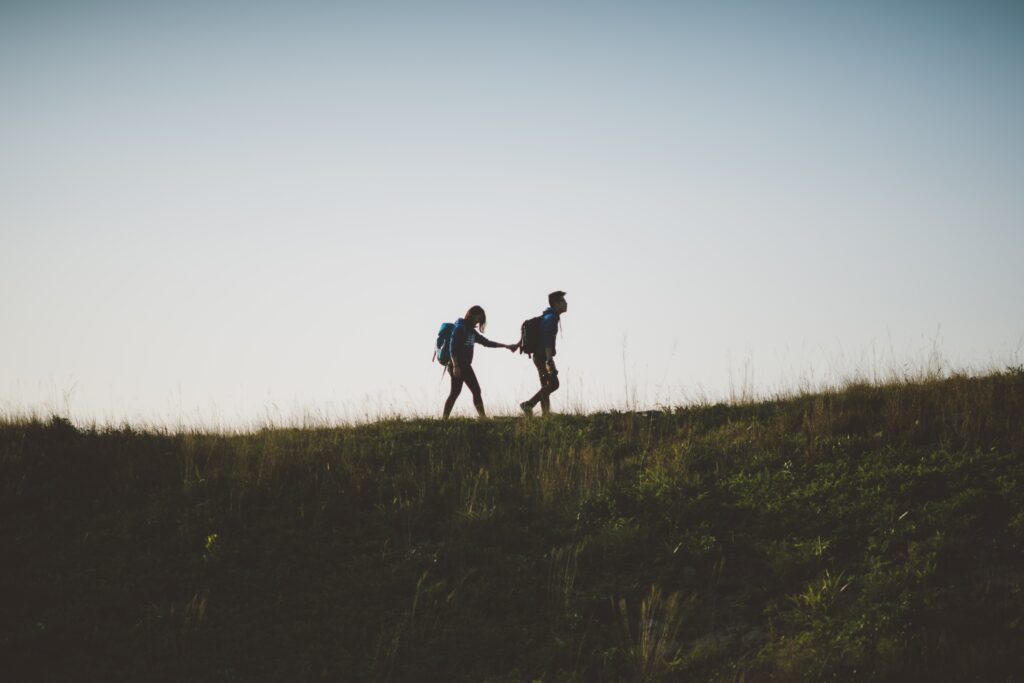 Storytelling und PR-Agenturen: Zwei Menschen laufen Hand in Hand über einen Hügel.
