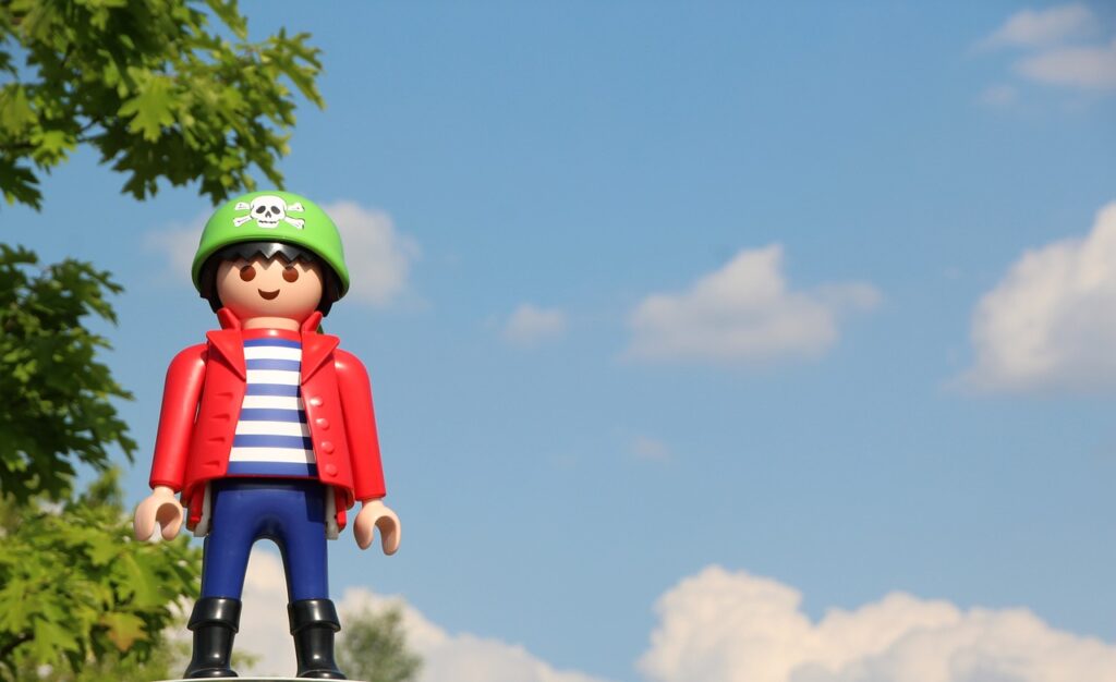 A Playmobil figure with a red jacket and green hat
